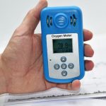 Co2 detector held in a hand, wearable tech.