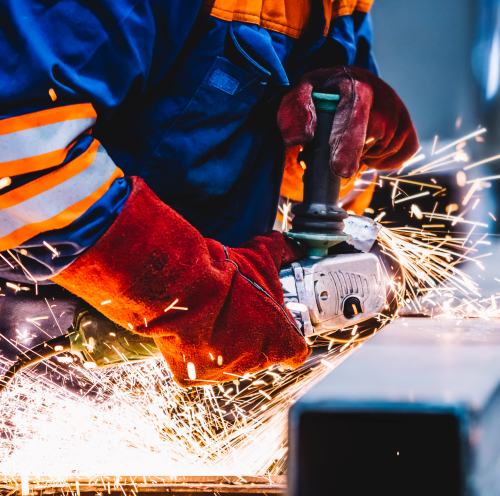 Worker grinding in a workshop. Heavy industry factory, metalwork