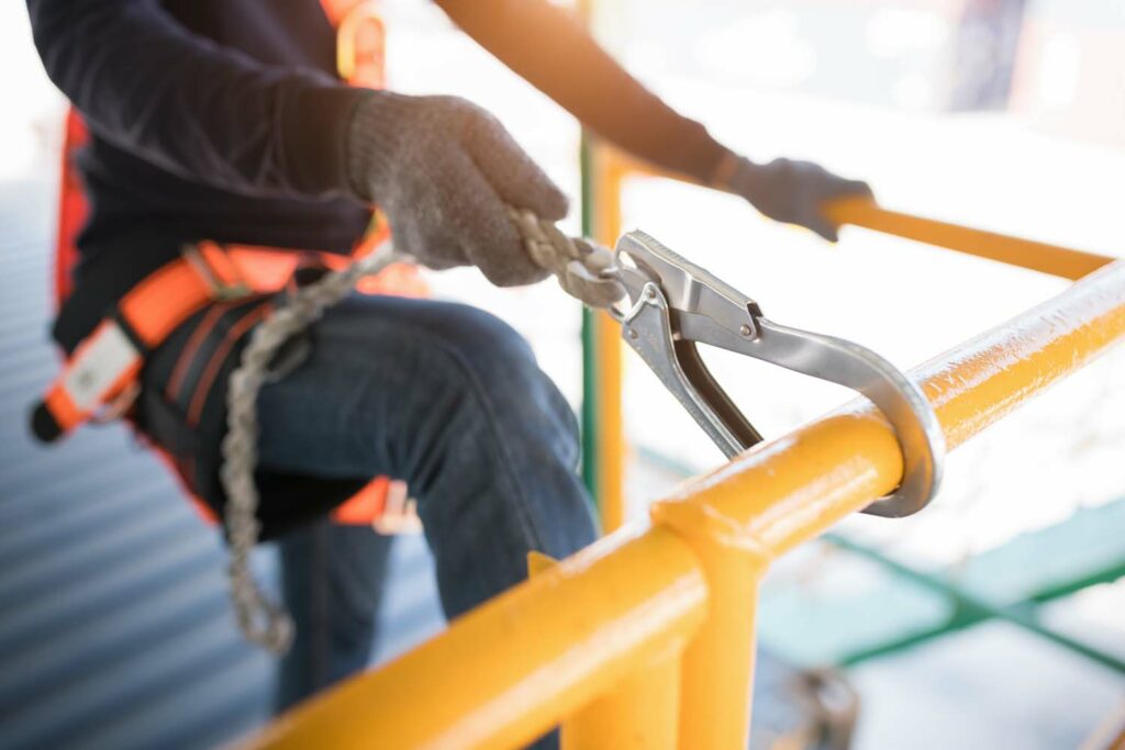 Construction worker wearing safety harness and safety line working at high place