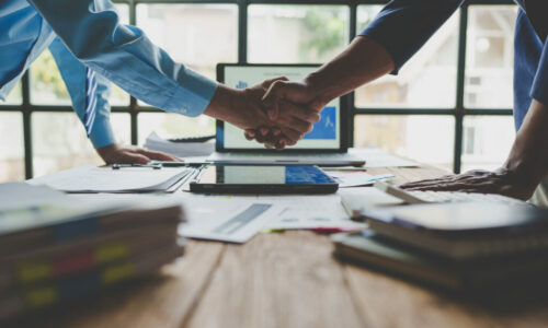 Young businessman and financial representative shaking hands after a budget deal for business expansion and investment in a village construction project real estate financial concept.