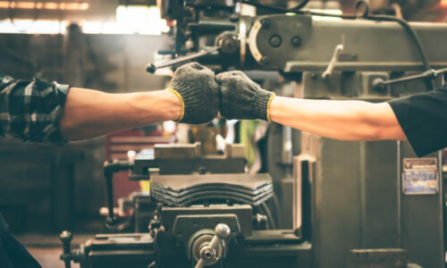 Experienced entrepreneurs, 2 engineers man Used hand for fist bump to show their cooperation For success teamwork, with blur soft of industrial machinery background, to people and synergy concept.