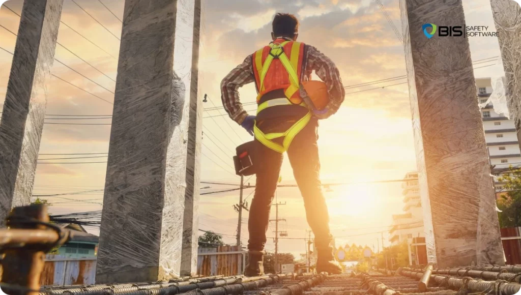 Four construction professionals in hard hats and reflective vests discuss plans at a building site, with scaffolding and residential structures in the background, emphasizing collaboration and safety.