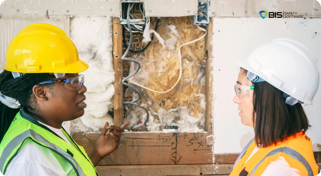 Two female construction workers discussing real hazards at a worksite, highlighting real people learning real lessons in safety practices.