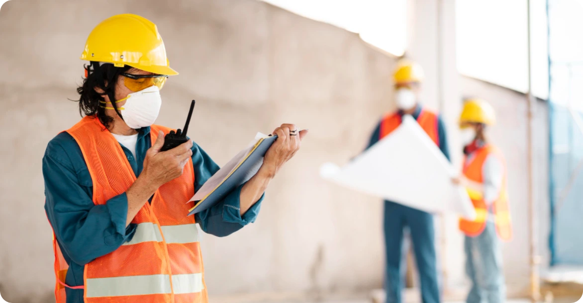 Construction supervisor checks notes during site planning, reinforcing the importance of active oversight in safety execution.