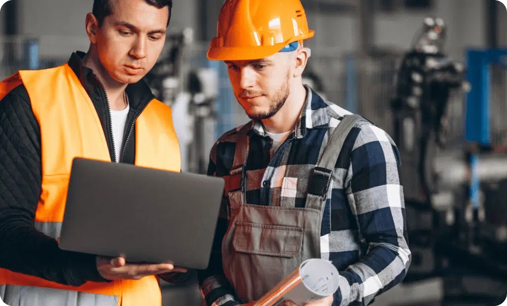 Coworkers collaborating and smiling on a job site, representing inclusive safety culture built through trust, teamwork, and shared responsibility—not top-down enforcement.