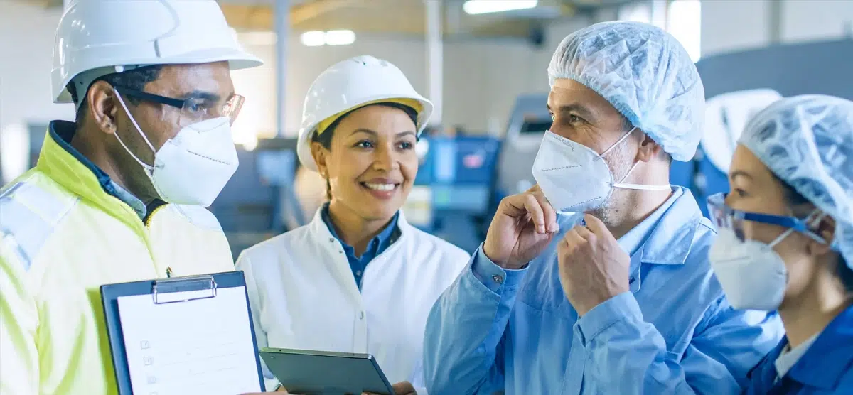 Gloved hand near hazard labels for flammable, corrosive, and toxic substances, highlighting lab safety risks. 