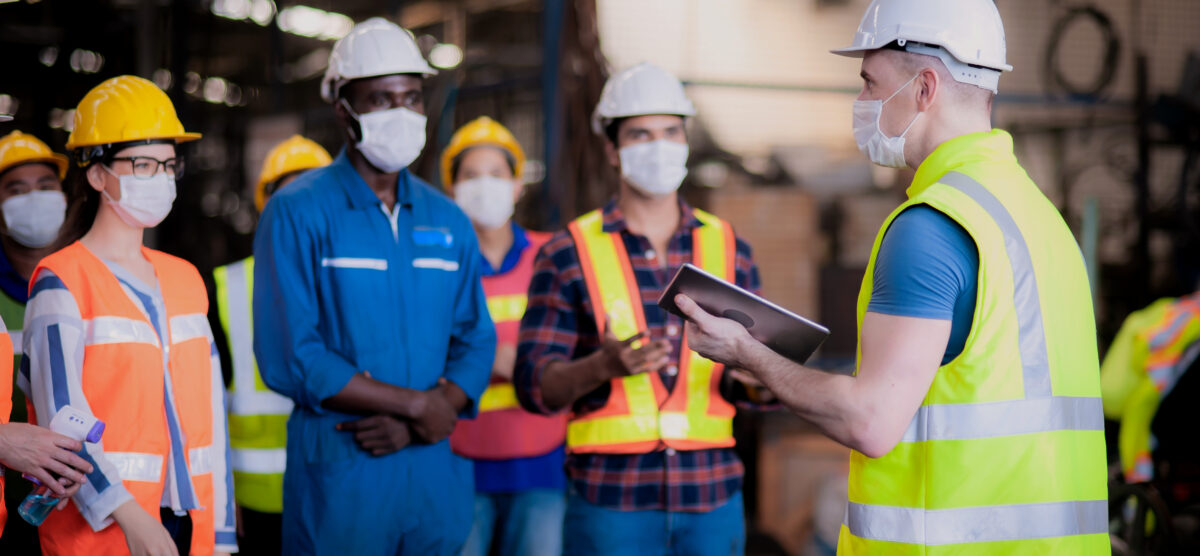 Safety worker holding a tablet for digital safety meeting tracking on-site.