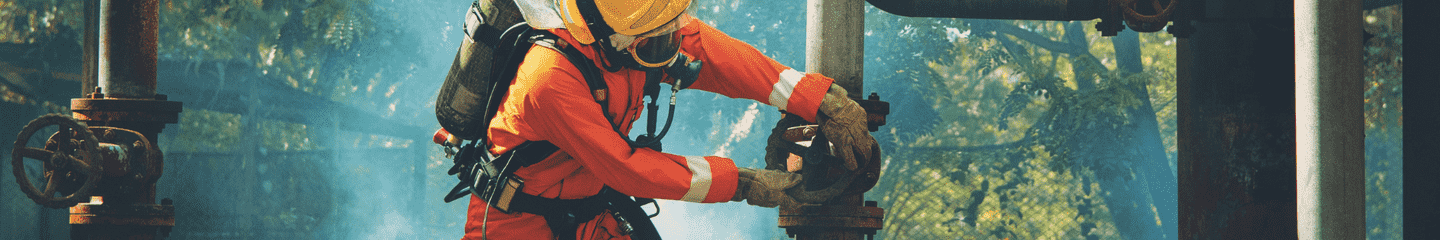 firefighter in an orange suit is working on a pipe