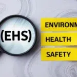 Magnifying glass showing EHS with yellow Environment, Health, and Safety labels.